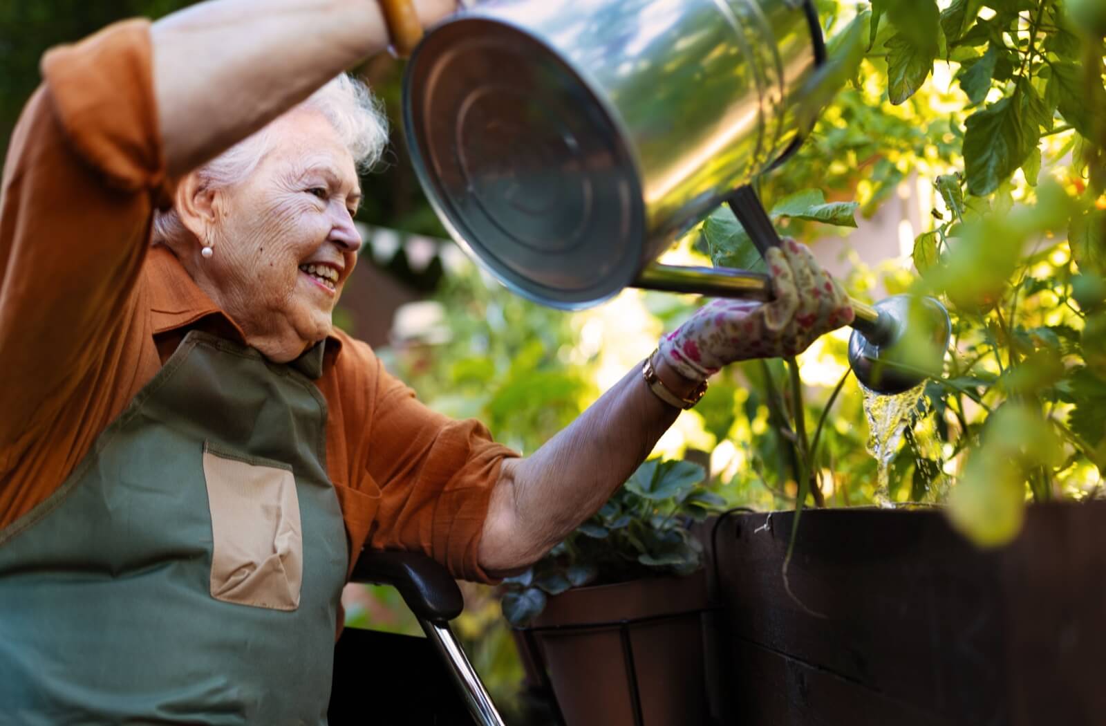 A senior woman enjoying gardening at her assisted living community.