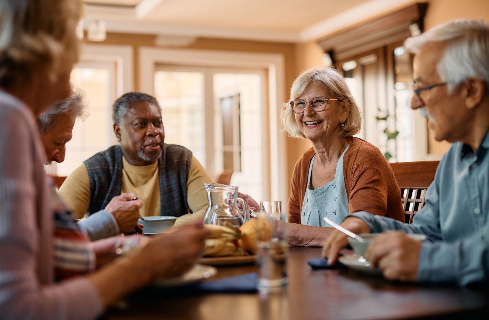 Group of senior friends socializing at an assisted living facility.